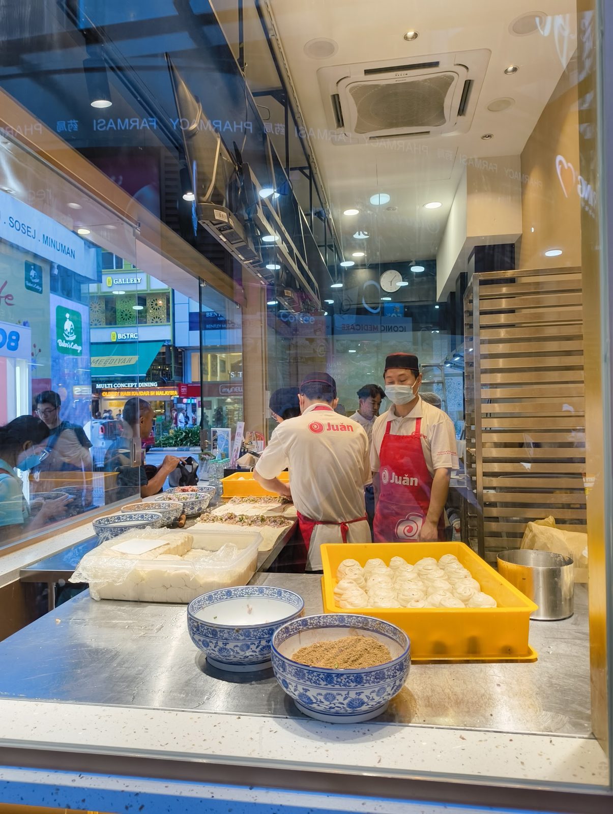 Inside the Juǎn kiosk kitchen with trays of dough balls